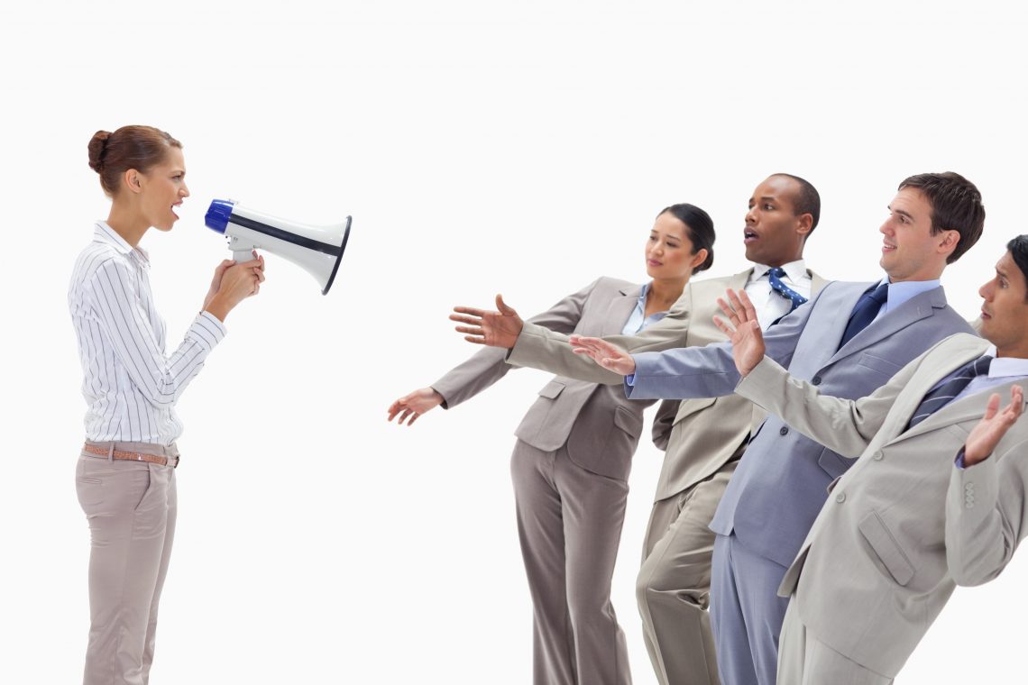 Woman yelling at people dressed in suits through a megaphone